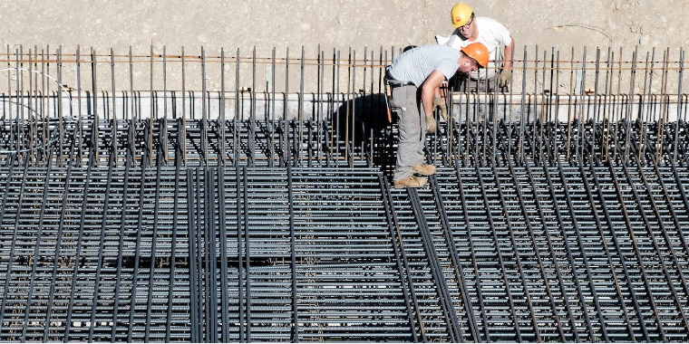 Uomini al lavoro in un cantiere: scopri i consigli e cosa sapere prima di acquistare o vendere un immobile.